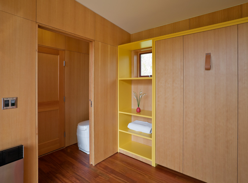 Foto de habitación de invitados moderna pequeña con paredes amarillas y suelo de madera en tonos medios