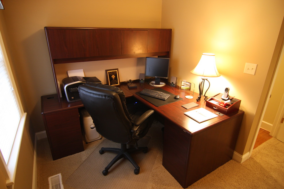Example of a large classic freestanding desk carpeted study room design in Other with beige walls