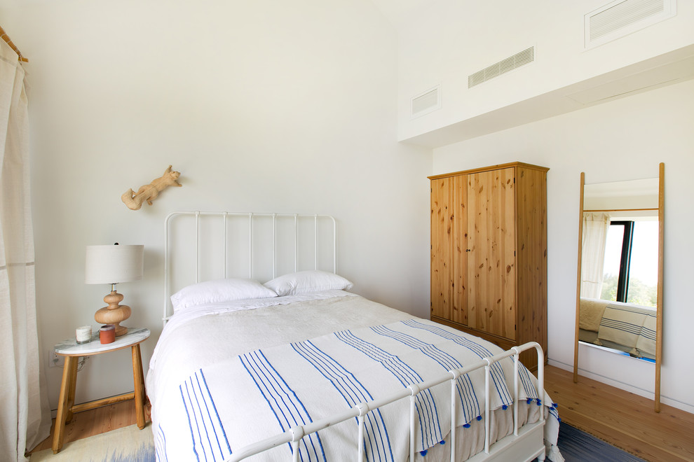 Exempel på ett lantligt sovrum, med vita väggar, mellanmörkt trägolv och brunt golv