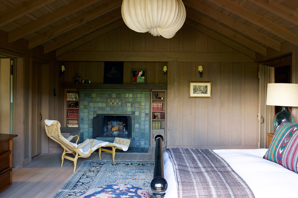 Rustikales Hauptschlafzimmer mit beiger Wandfarbe, hellem Holzboden, Kamin und gefliester Kaminumrandung in Los Angeles