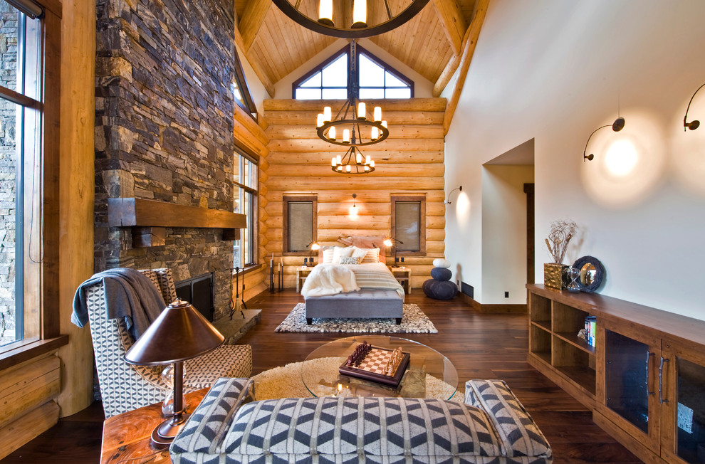 Design ideas for a rustic grey and silver bedroom in Calgary with a stone fireplace surround and feature lighting.