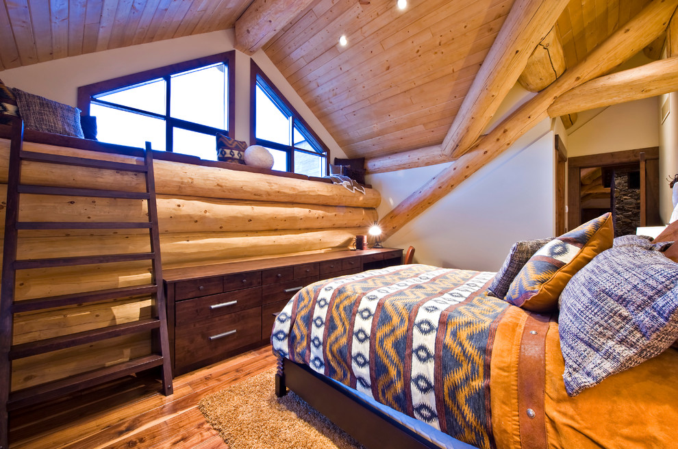 Esempio di un'In mansarda camera da letto stile rurale con pareti beige e pavimento in legno massello medio