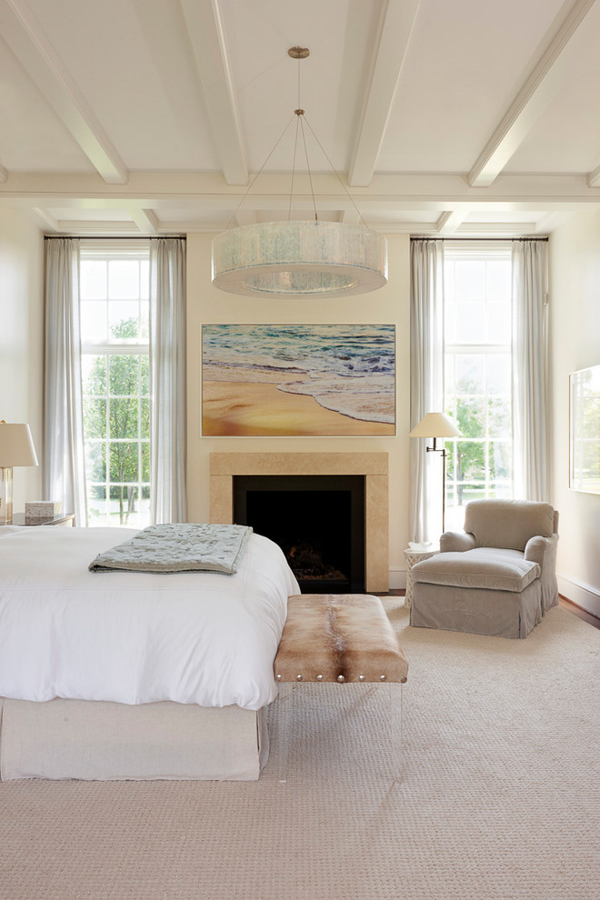 Foto di una camera da letto tradizionale con pareti beige, moquette, camino classico e pavimento beige
