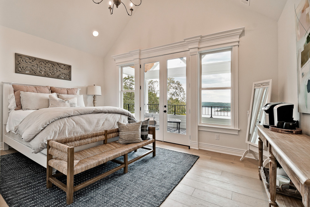 This is an example of a large classic guest bedroom in Other with white walls and light hardwood flooring.