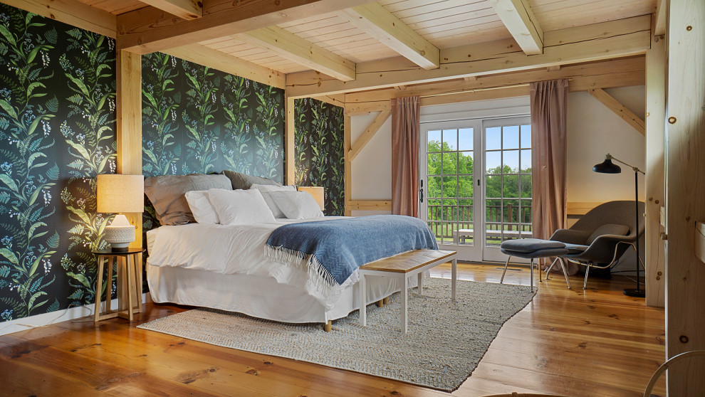 Großes Landhaus Hauptschlafzimmer mit weißer Wandfarbe, braunem Holzboden, freigelegten Dachbalken und Tapetenwänden in New York