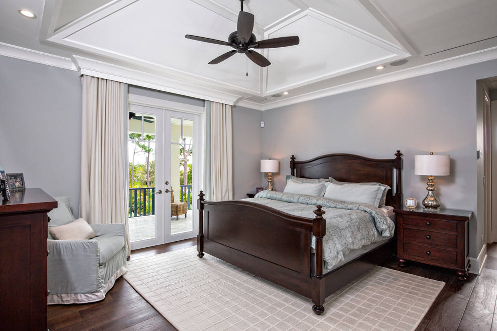 This is an example of a medium sized beach style master bedroom in Miami with grey walls and dark hardwood flooring.