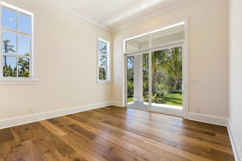 Diseño de habitación de invitados blanca y blanca y madera costera grande con paredes blancas, suelo de madera en tonos medios y suelo marrón