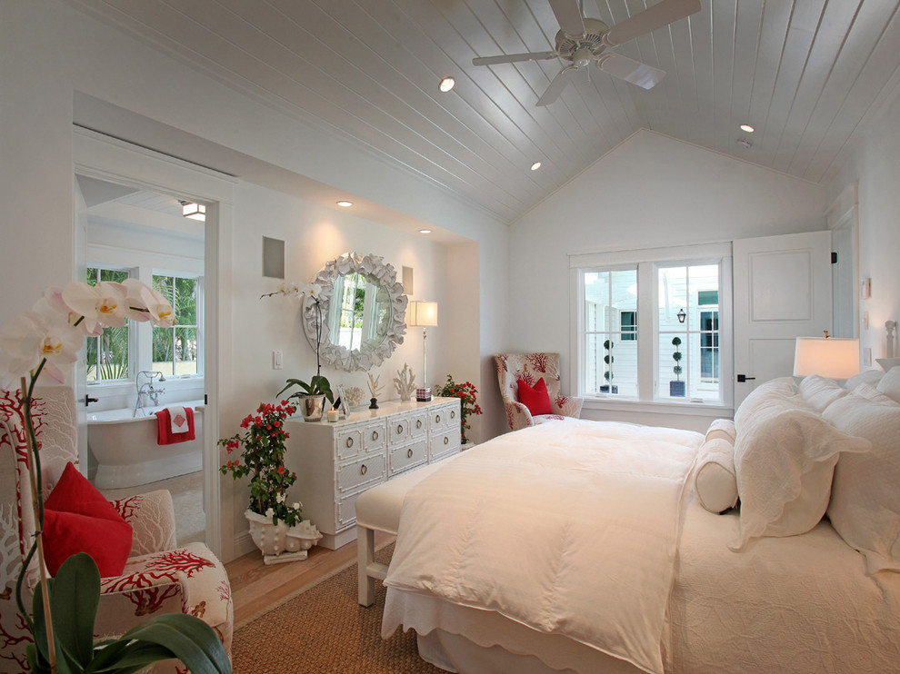 Ejemplo de dormitorio principal marinero de tamaño medio sin chimenea con paredes blancas y suelo de madera en tonos medios