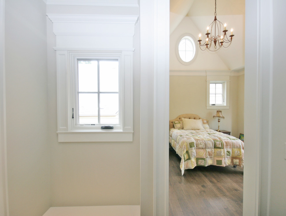 Modelo de habitación de invitados tradicional de tamaño medio con paredes beige y suelo de madera en tonos medios