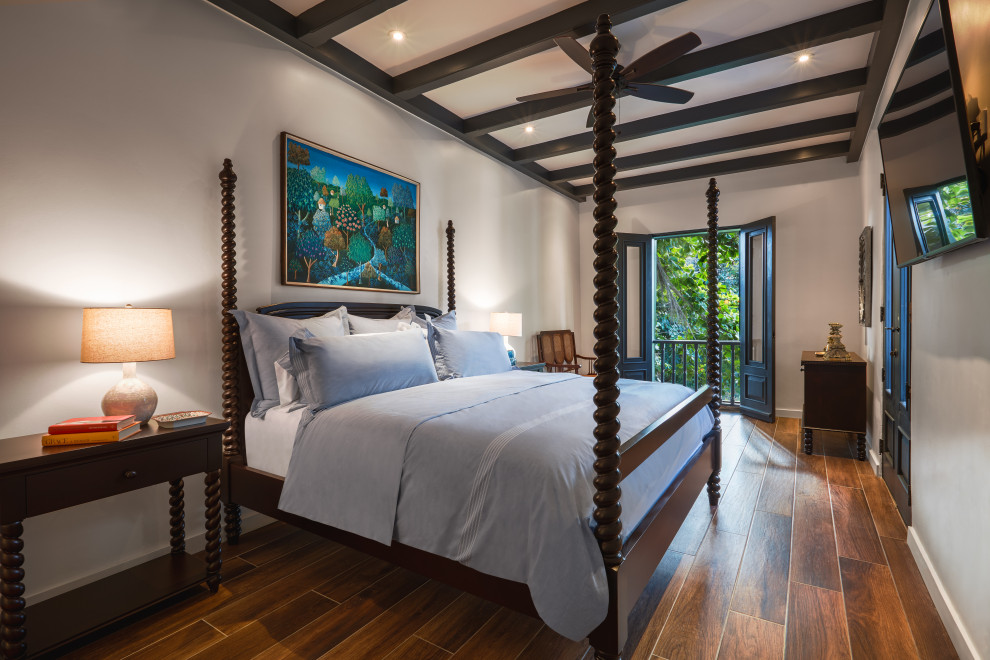 Expansive world-inspired master bedroom in Other with white walls, ceramic flooring and brown floors.