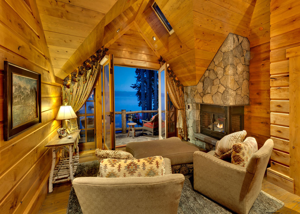 Idée de décoration pour une chambre parentale design avec un mur beige, un sol en bois brun, un manteau de cheminée en pierre et une cheminée standard.