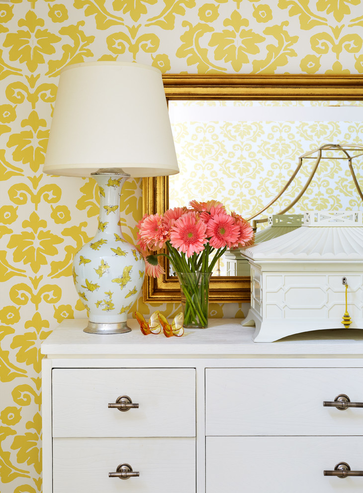 Aménagement d'une chambre mansardée ou avec mezzanine classique avec un mur jaune et parquet foncé.