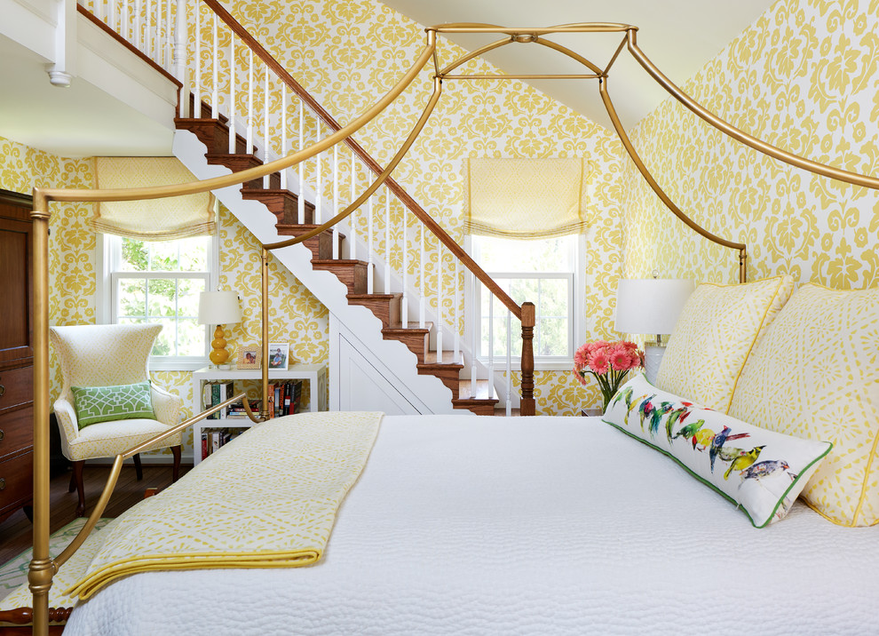 Exempel på ett klassiskt sovrum, med gula väggar och mellanmörkt trägolv