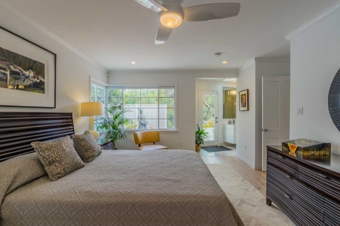 Photo of a large retro master bedroom in San Diego with white walls and light hardwood flooring.