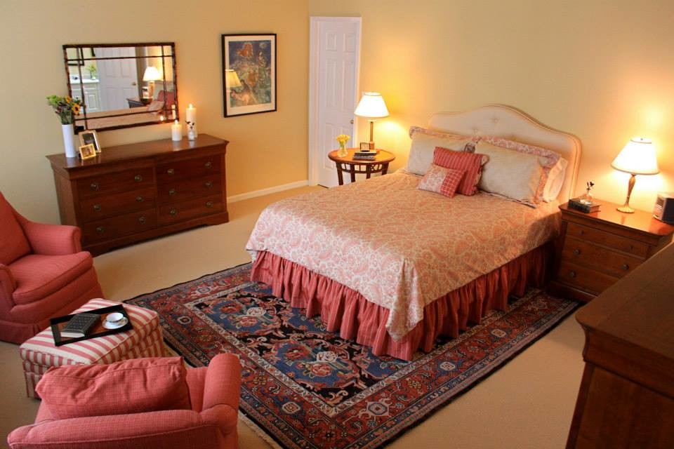 Ejemplo de dormitorio tradicional sin chimenea con moqueta y paredes amarillas