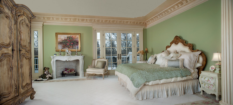 Exemple d'une très grande chambre parentale chic avec un mur vert, un sol en marbre, une cheminée standard et un manteau de cheminée en pierre.