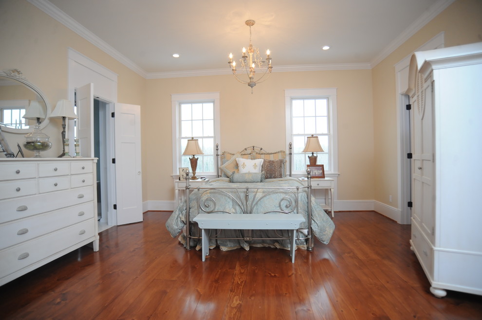 Ejemplo de dormitorio principal de estilo de casa de campo grande con paredes blancas y suelo de madera en tonos medios