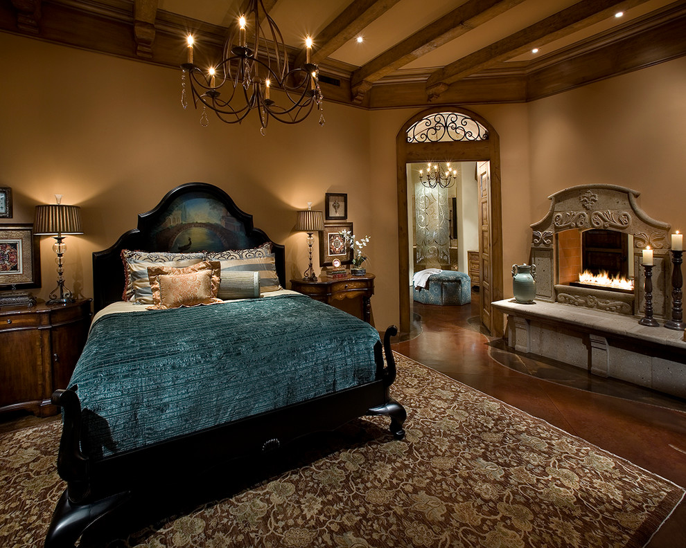 Large traditional master bedroom in Orange County with a two-sided fireplace, beige walls, concrete flooring, a stone fireplace surround and brown floors.