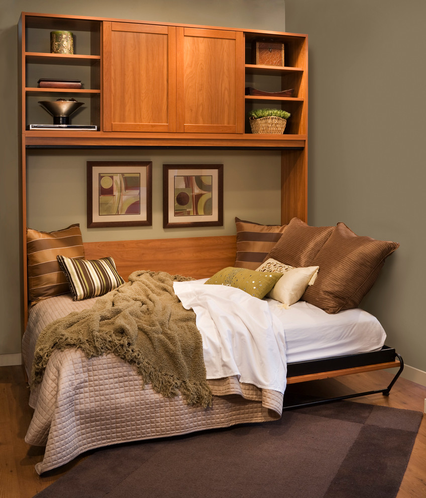 Modelo de habitación de invitados de estilo americano de tamaño medio con paredes verdes y suelo de madera en tonos medios