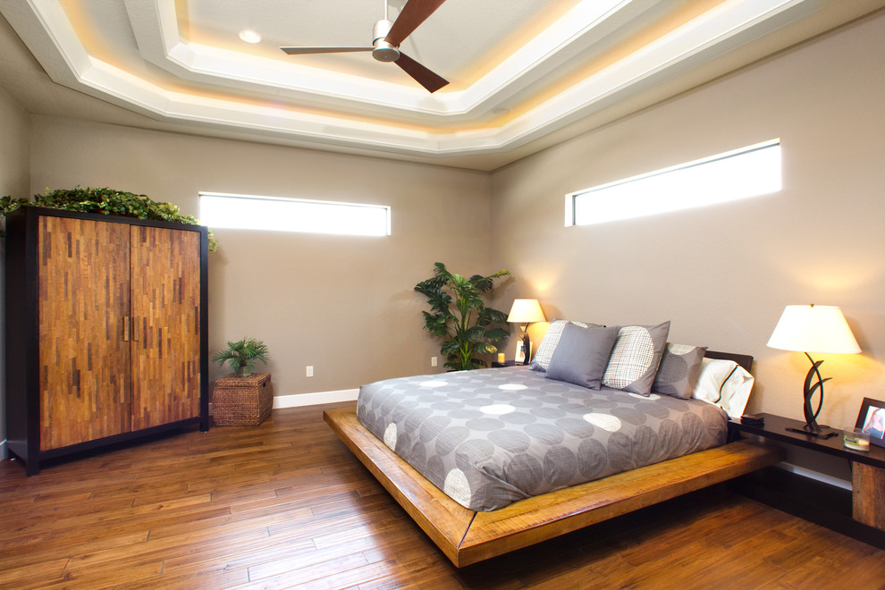 Ejemplo de dormitorio principal actual de tamaño medio sin chimenea con paredes beige, suelo de madera oscura y suelo marrón