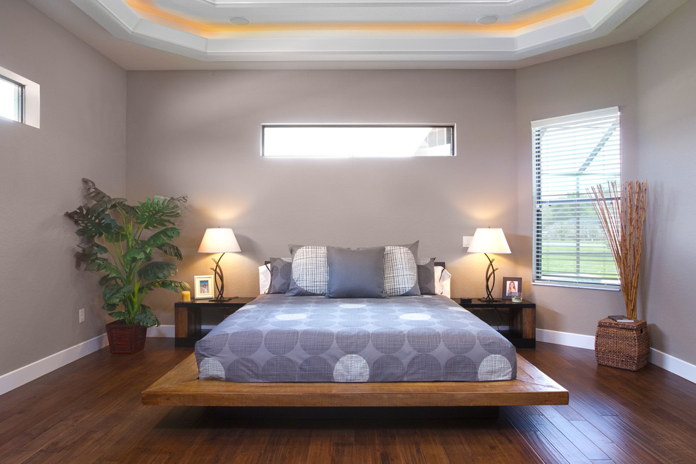 Imagen de dormitorio principal actual de tamaño medio sin chimenea con paredes beige, suelo de madera oscura y suelo marrón