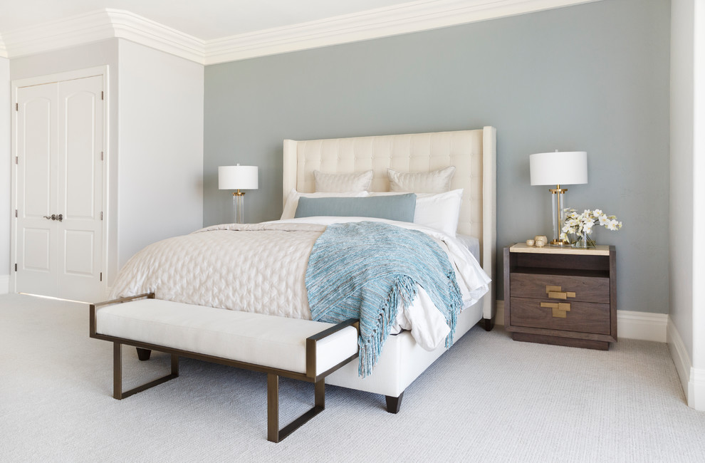 Inredning av ett modernt sovrum, med blå väggar, heltäckningsmatta och beiget golv