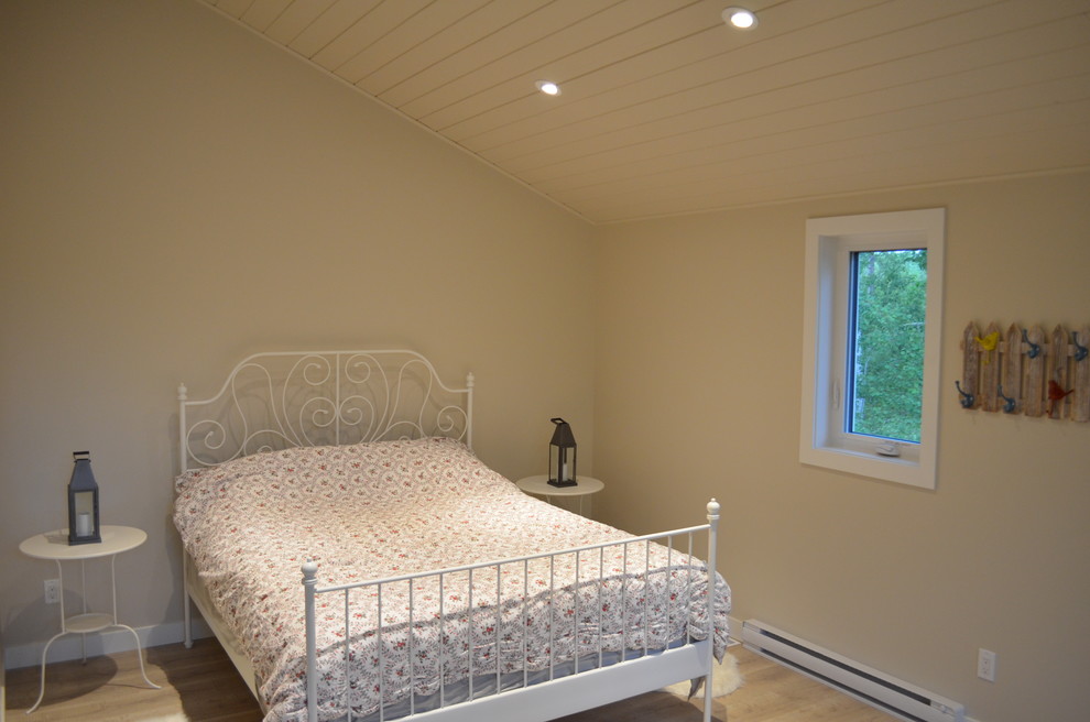 Idee per una camera matrimoniale minimalista di medie dimensioni con pareti beige, pavimento in laminato e pavimento beige