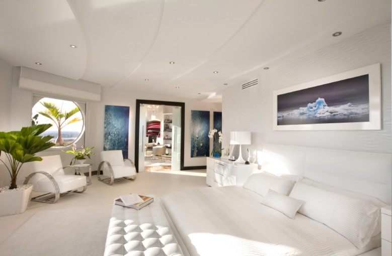 Imagen de dormitorio principal minimalista de tamaño medio con paredes grises, suelo de piedra caliza y todas las chimeneas