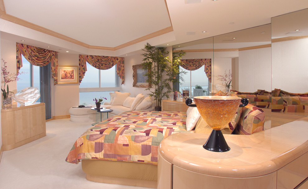 Design ideas for an expansive contemporary master bedroom in Miami with beige walls and carpet.