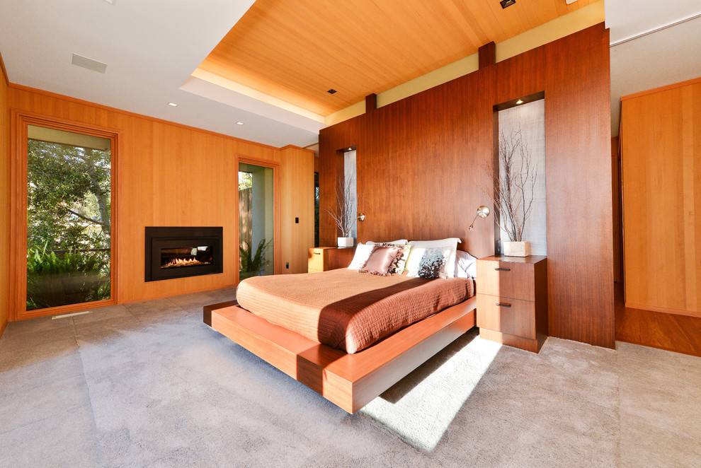 Large contemporary master bedroom in San Francisco with carpet, a ribbon fireplace and a wooden fireplace surround.