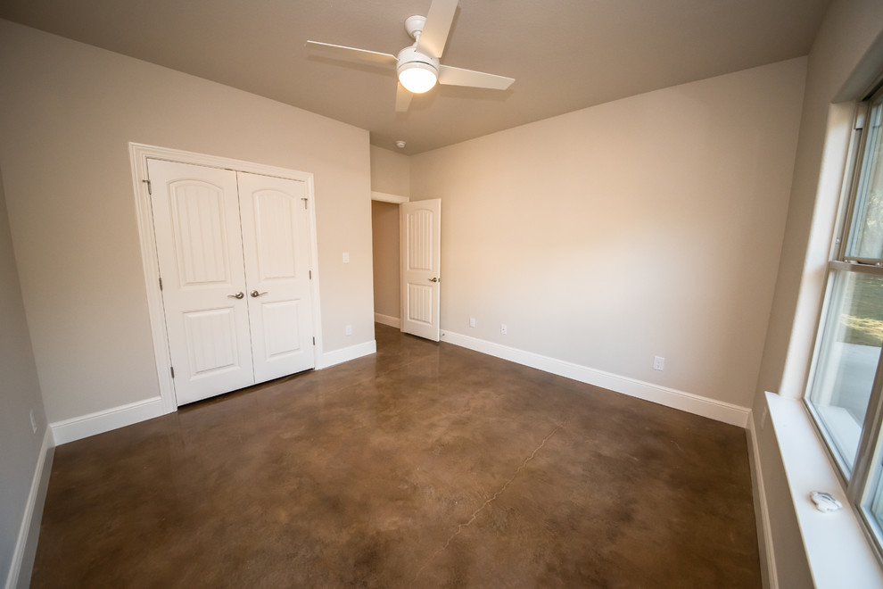 Inspiration for a large craftsman master concrete floor bedroom remodel in Austin with beige walls
