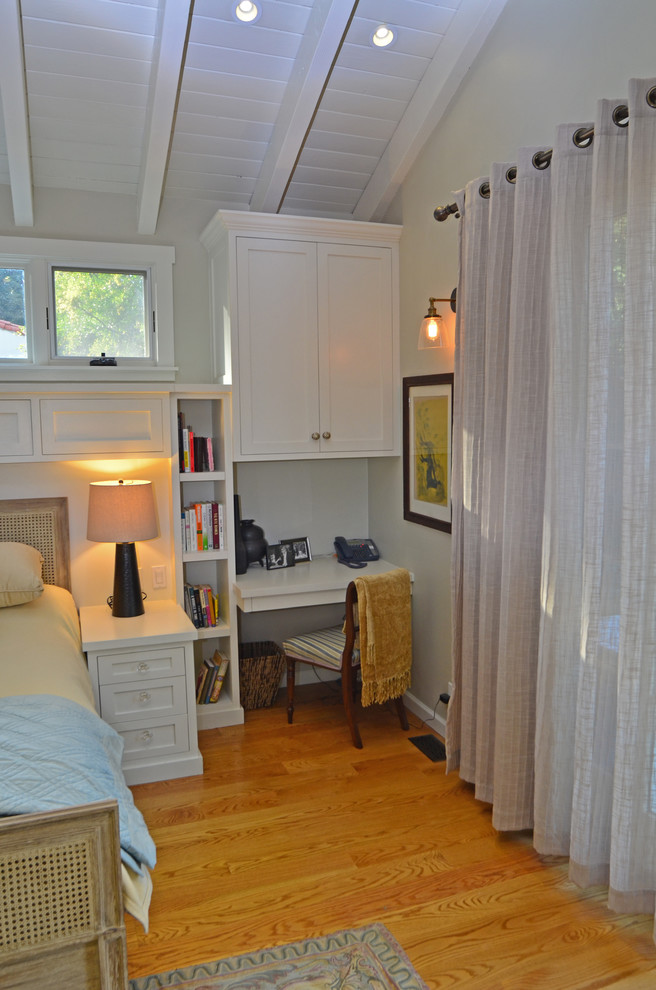 Cette image montre une chambre parentale bohème de taille moyenne avec un mur beige, un sol en bois brun et aucune cheminée.