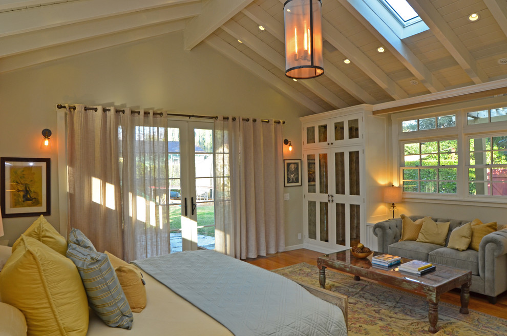 Ejemplo de dormitorio principal bohemio de tamaño medio sin chimenea con paredes beige y suelo de madera en tonos medios