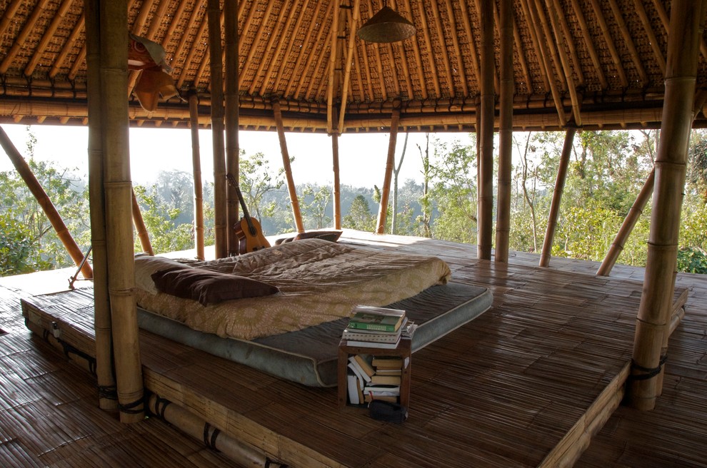Diseño de dormitorio exótico sin chimenea con suelo de bambú