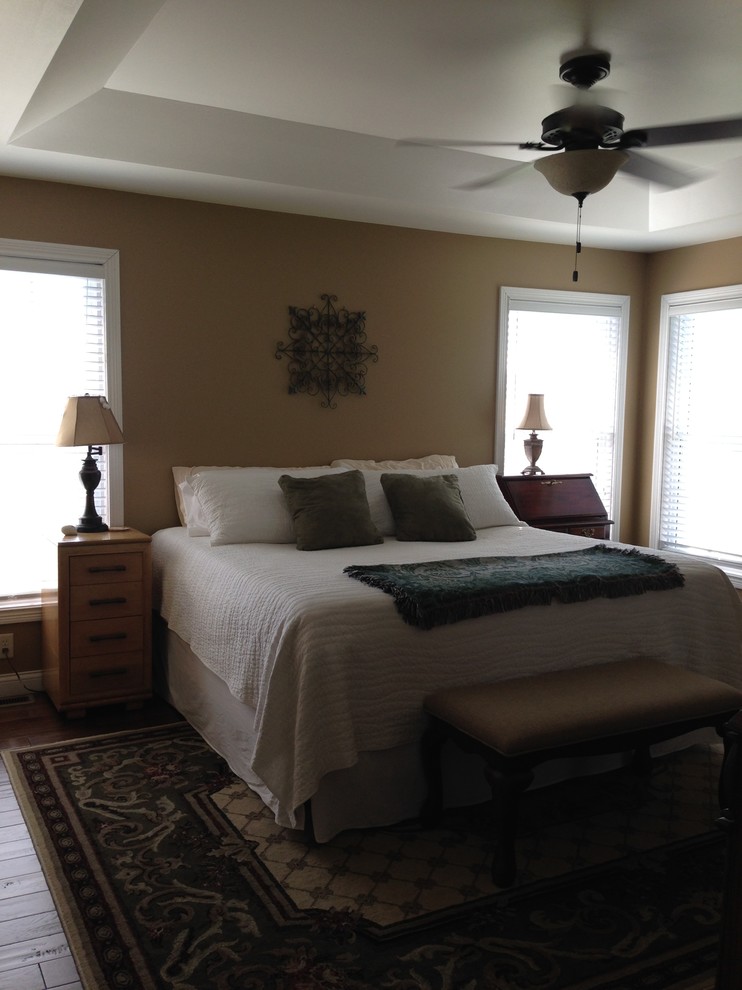 Klassisches Hauptschlafzimmer mit brauner Wandfarbe und braunem Holzboden in Sonstige