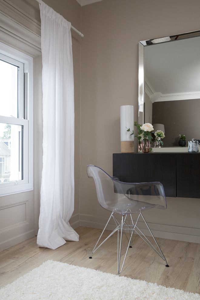 Ejemplo de dormitorio de tamaño medio con paredes beige y suelo de madera clara