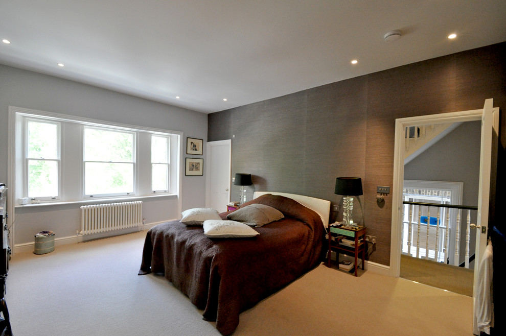 This is an example of a medium sized contemporary master bedroom in London with grey walls and carpet.