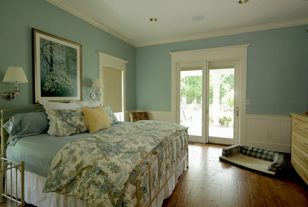 Immagine di una grande camera matrimoniale country con pareti blu e pavimento in legno massello medio