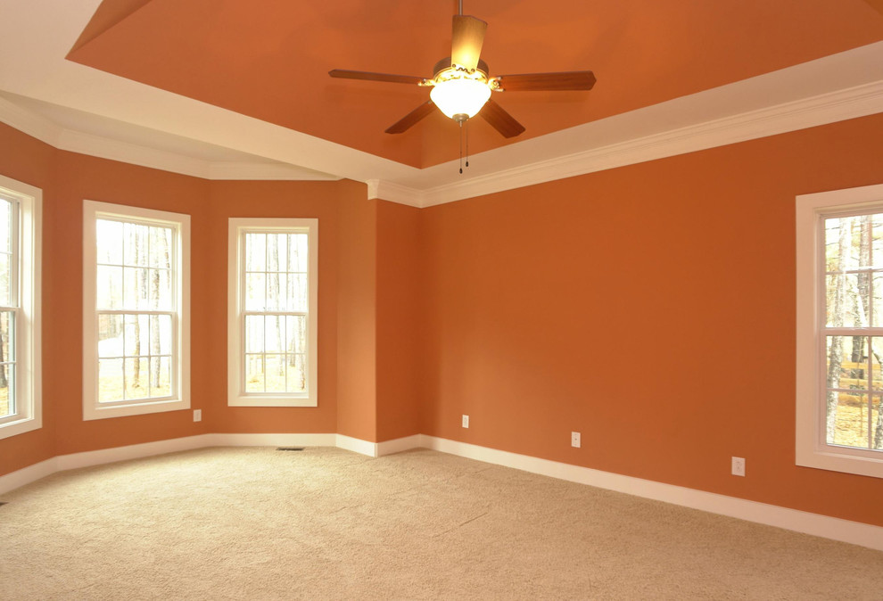 Großes Klassisches Hauptschlafzimmer mit oranger Wandfarbe und Teppichboden in Raleigh