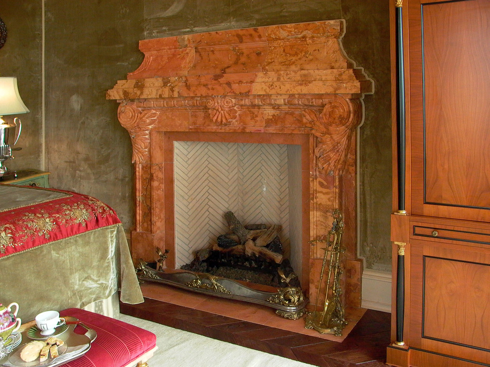 Imagen de dormitorio principal clásico grande con paredes verdes, suelo de madera oscura y marco de chimenea de piedra