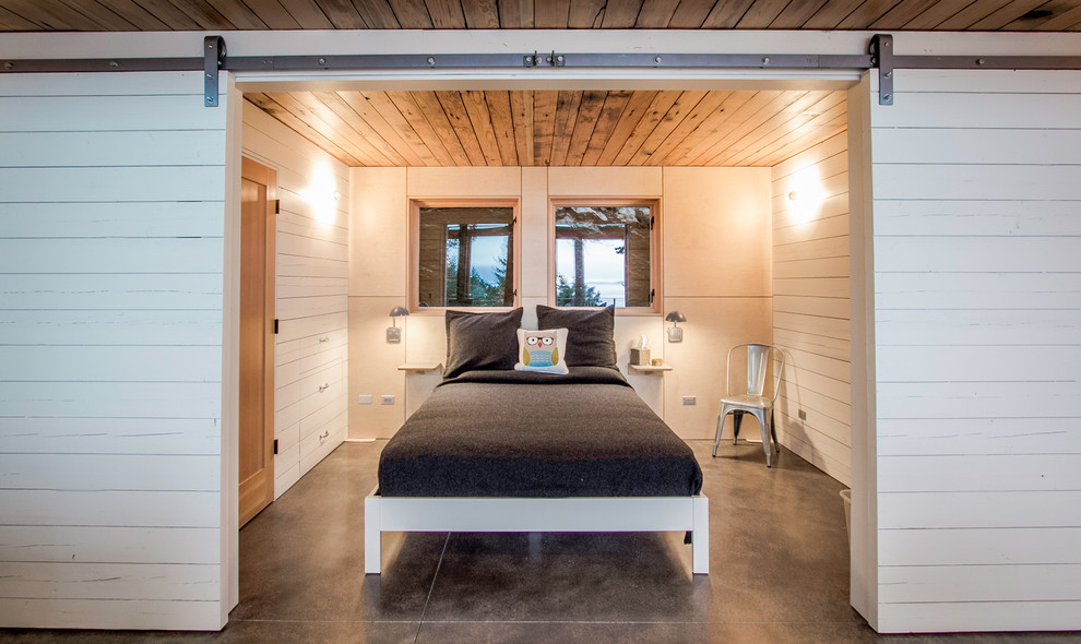 シアトルにある中くらいなラスティックスタイルのおしゃれな客用寝室 (コンクリートの床、白い壁、暖炉なし、グレーの床) のインテリア