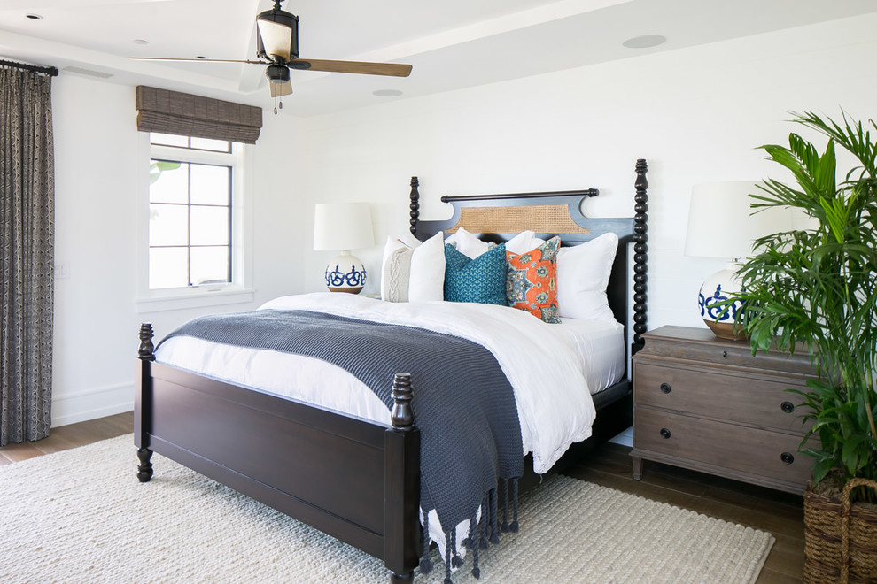 Inspiration for a large tropical master medium tone wood floor and brown floor bedroom remodel in Orange County with white walls and a standard fireplace