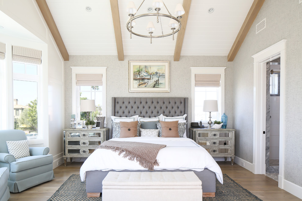 This is an example of a coastal master and grey and cream bedroom in Orange County with grey walls.