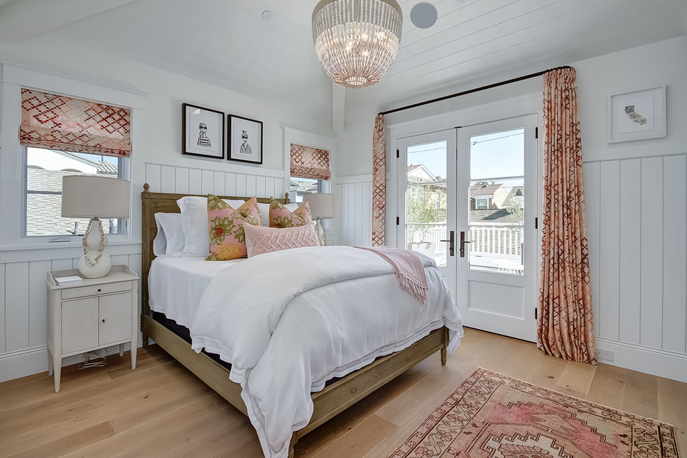 Beach style bedroom in Orange County with white walls and light hardwood flooring.
