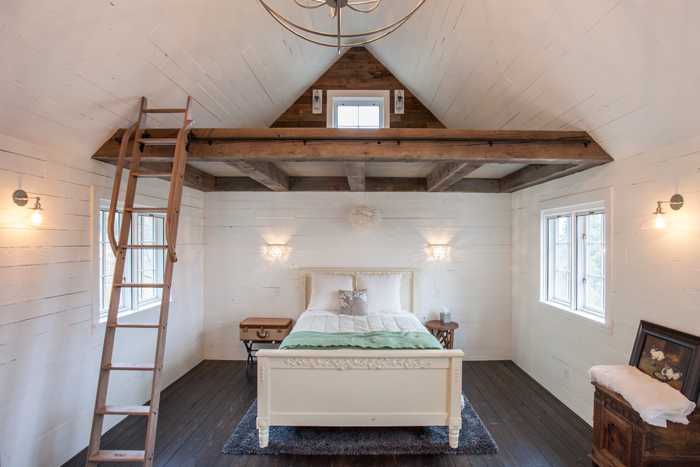 Foto på ett mellanstort lantligt sovrum, med vita väggar och mörkt trägolv