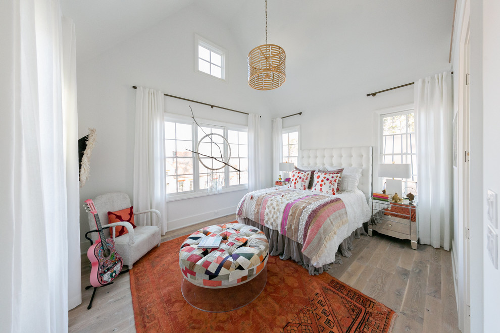 Imagen de habitación de invitados ecléctica de tamaño medio con paredes blancas, suelo marrón y suelo de madera clara
