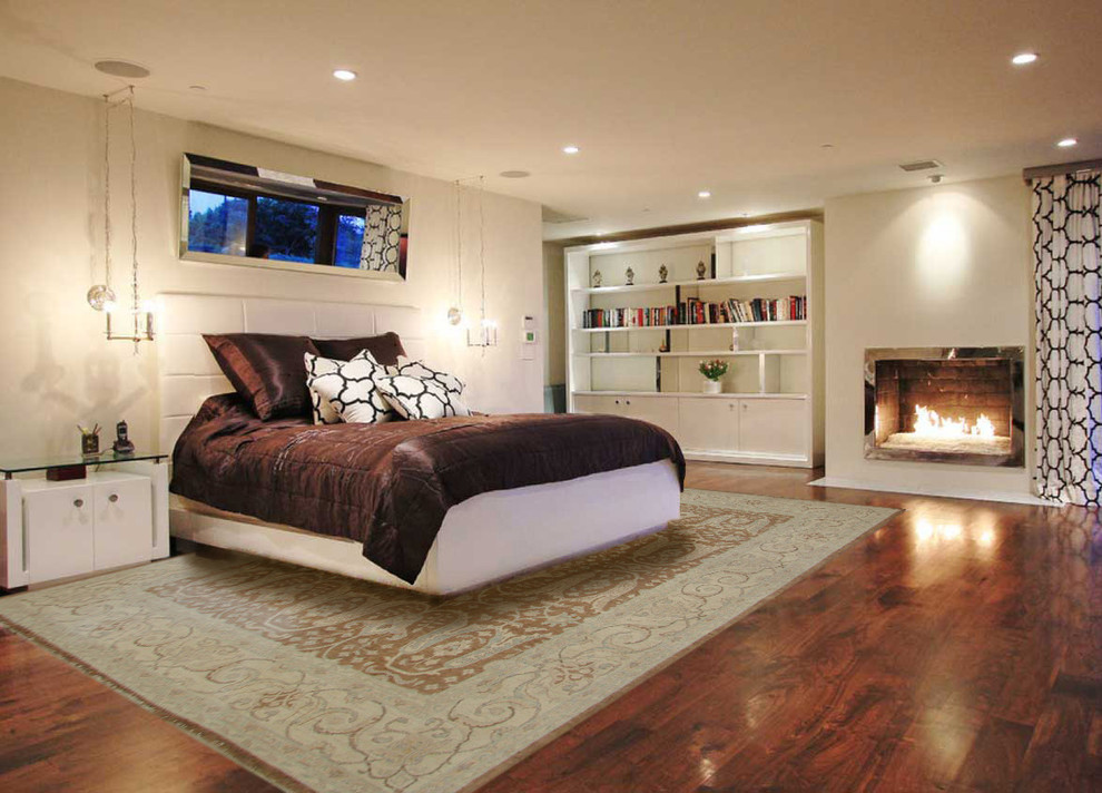 На фото: большая хозяйская спальня в стиле неоклассика (современная классика) с бежевыми стенами, темным паркетным полом, стандартным камином, фасадом камина из металла и коричневым полом
