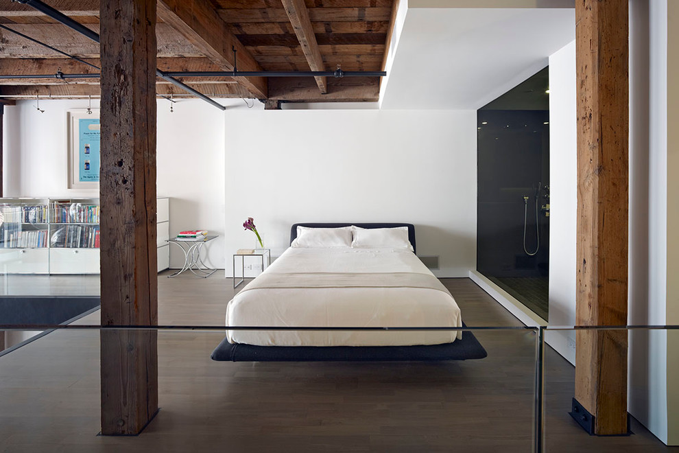 Esempio di una piccola camera da letto stile loft industriale con pareti bianche, parquet chiaro e nessun camino