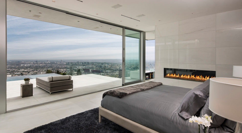 Contemporary bedroom in Orange County with a ribbon fireplace and a tiled fireplace surround.