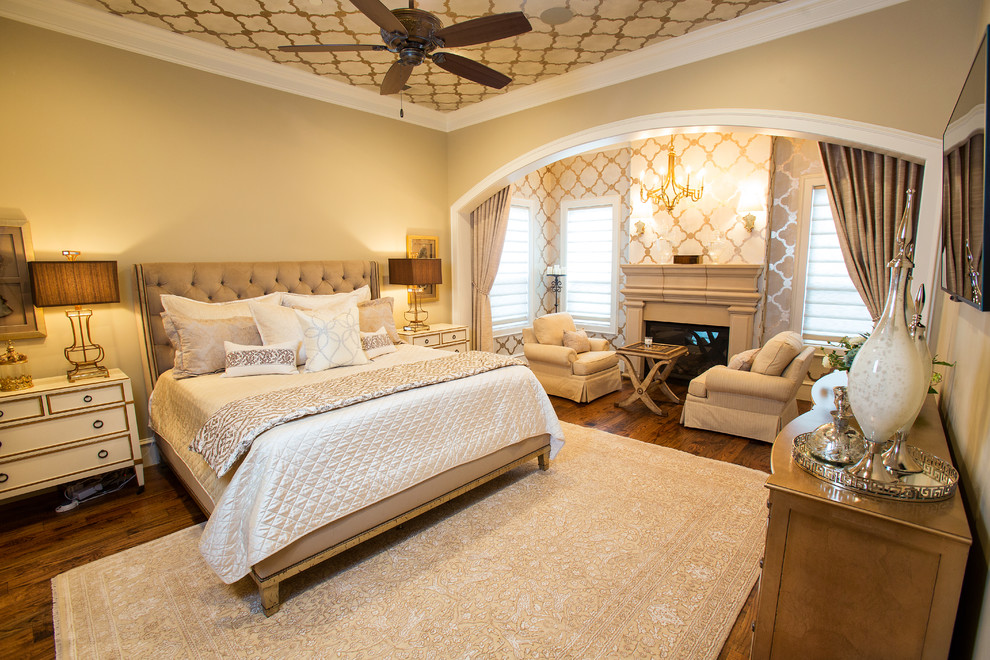 Klassisches Schlafzimmer mit beiger Wandfarbe, dunklem Holzboden und Kamin in Dallas